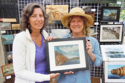 Christine Post (left) purchased Lisa Johnson's (right) painting titled Rekr's Rock at the Bon Echo Art Exhibition and Sale